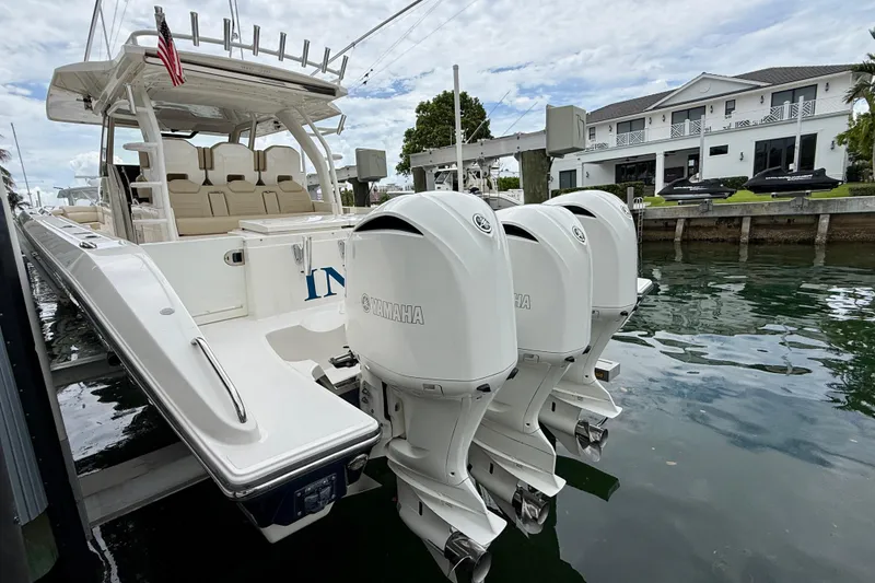 Slide: The Image of 2018 Pursuit S 408 Sport boat docked with triple Yamaha outboard engines. - 21