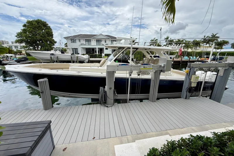 Slide: The Image of 2018 Pursuit S 408 Sport boat docked near waterfront home. - 22