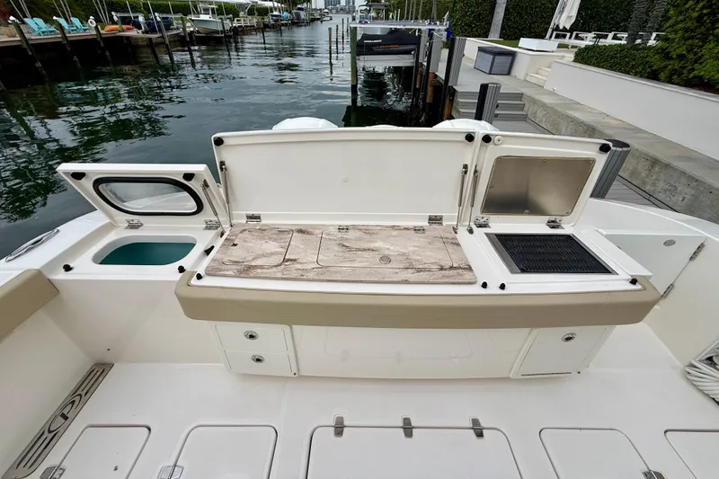 Slide: The Image of 2018 Pursuit S 408 Sport boat with open storage compartments at dockside. - 32