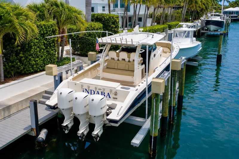 Slide: The Image of 2018 Pursuit S 408 Sport boat docked with triple outboard engines. - 4