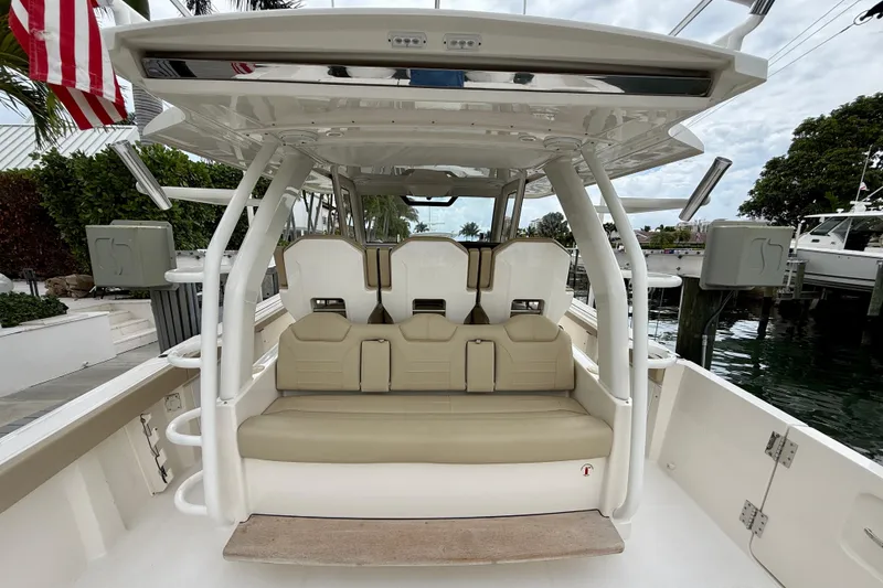 Slide: The Image of 2018 Pursuit S 408 Sport boat interior with seating and canopy, docked near water. - 43