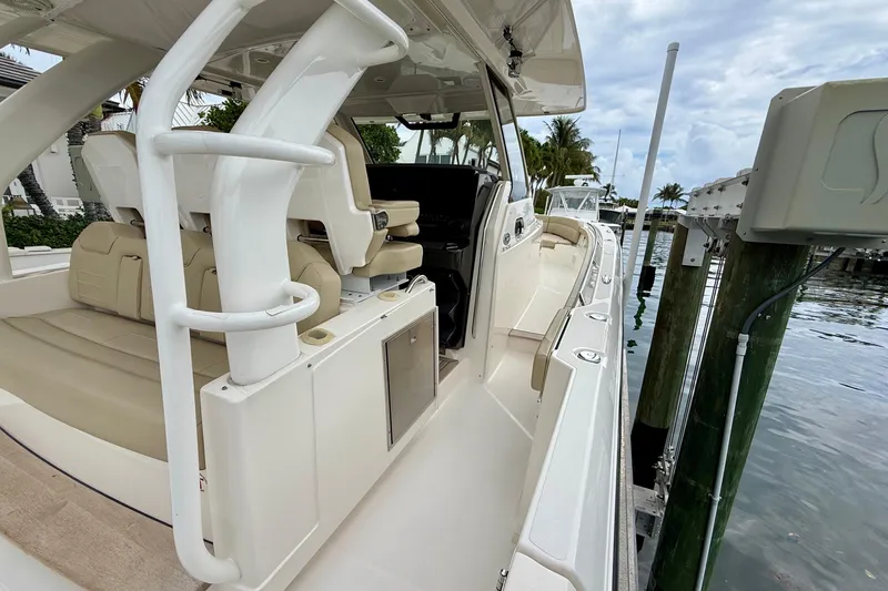 Slide: The Image of 2018 Pursuit S 408 Sport boat docked, showcasing sleek design and luxurious seating. - 47