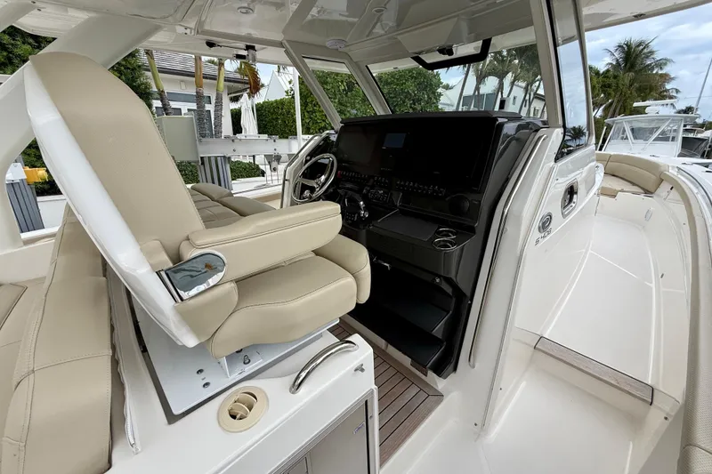 Slide: The Image of 2018 Pursuit S 408 Sport boat interior with helm and seating area. - 52