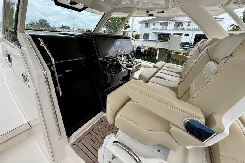 Slide: The Image of 2018 Pursuit S 408 Sport boat interior with beige seating and modern dashboard. - 53