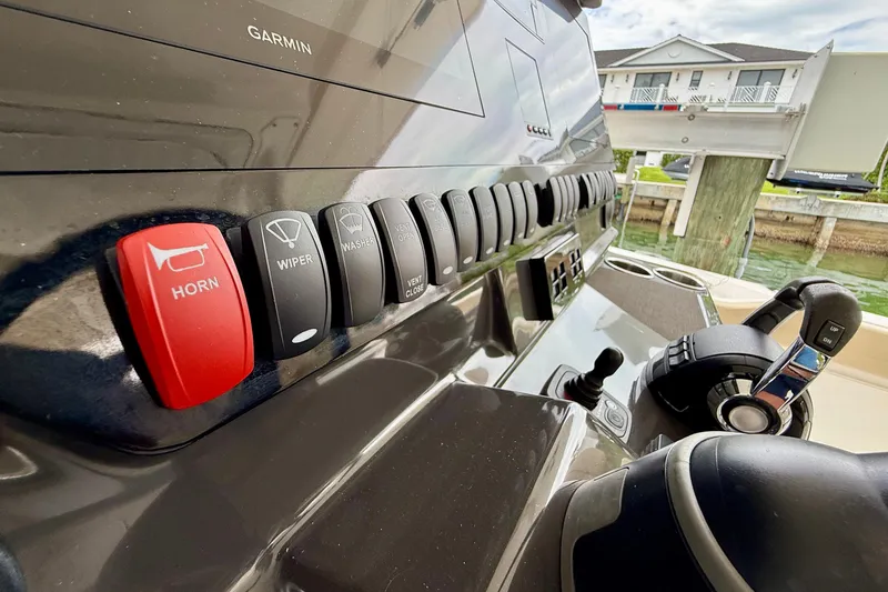 Slide: The Image of Control panel of a 2018 Pursuit S 408 Sport boat with various switches and controls. - 57