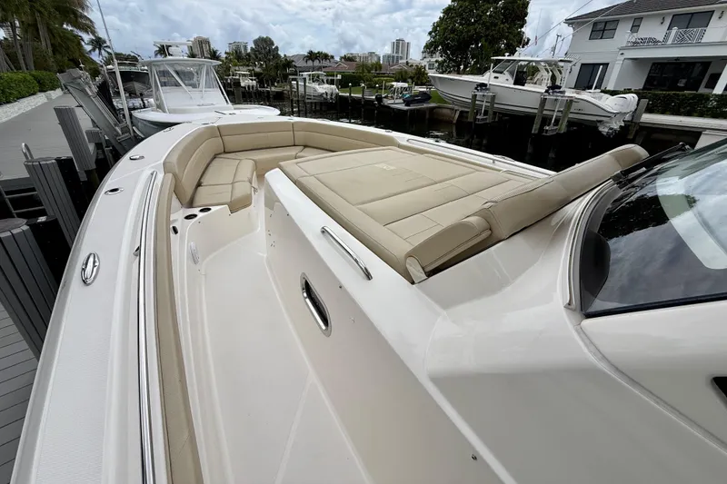 Slide: The Image of 2018 Pursuit S 408 Sport boat with spacious seating, docked in a marina. - 63