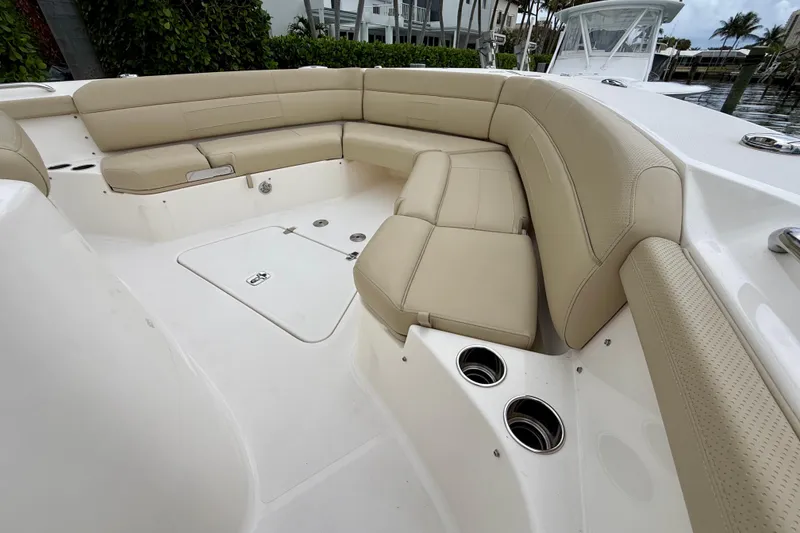 Slide: The Image of 2018 Pursuit S 408 Sport boat interior with beige seating and cup holders. - 65