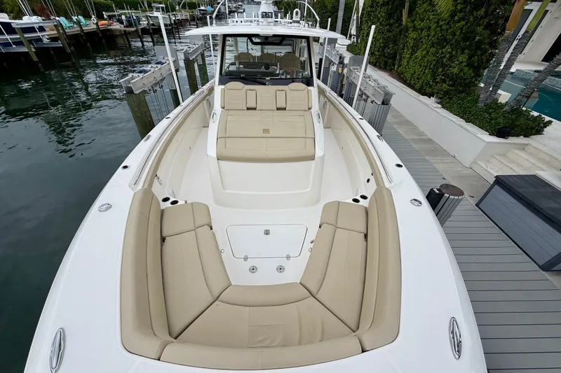 Slide: The Image of 2018 Pursuit S 408 Sport boat with beige seating, docked by the water. - 68
