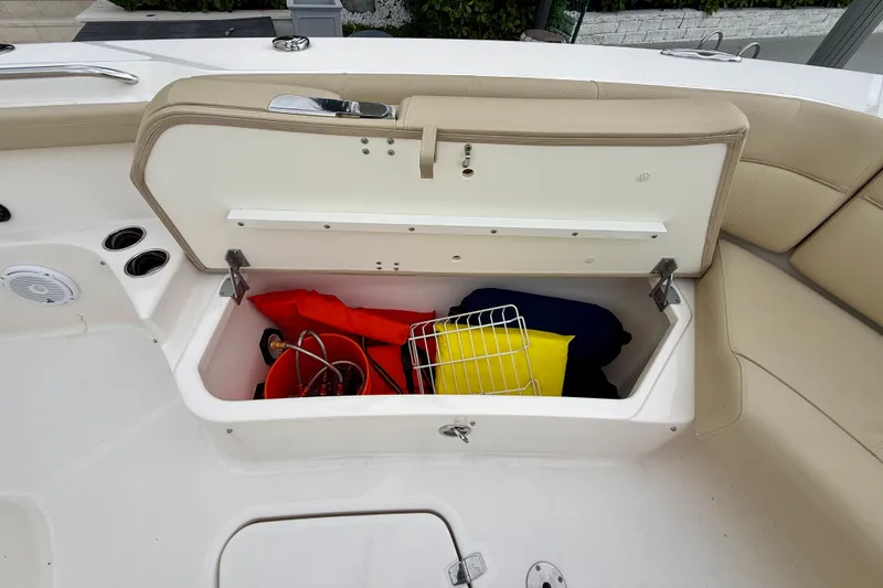 Slide: The Image of Storage compartment on a 2018 Pursuit S 408 Sport boat with life jackets and accessories. - 71