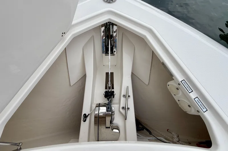 Slide: The Image of Anchor compartment of a 2018 Pursuit S 408 Sport boat, featuring fresh and raw water outlets. - 74