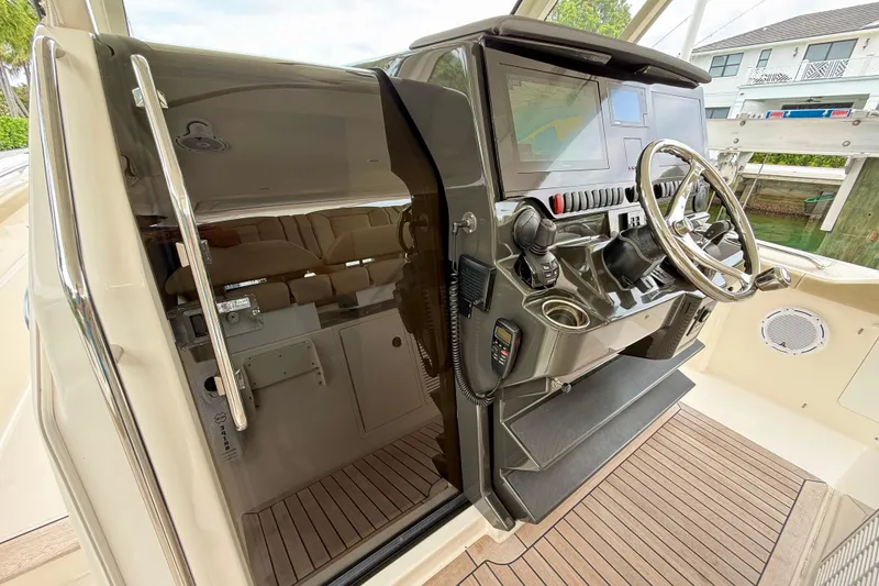 Slide: The Image of 2018 Pursuit S 408 Sport boat helm with steering wheel and navigation display. - 76