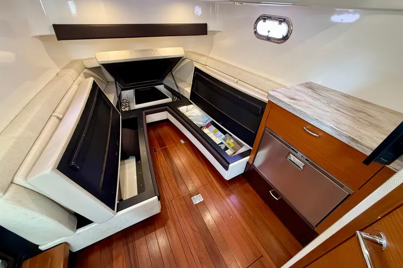 Slide: The Image of 2018 Pursuit S 408 Sport cabin interior with storage compartments and wooden flooring. - 79
