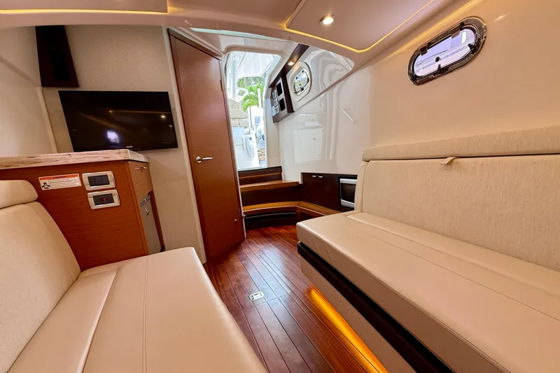 Slide: The Image of Luxurious interior of 2018 Pursuit S 408 Sport boat with seating, TV, and wood flooring. - 81