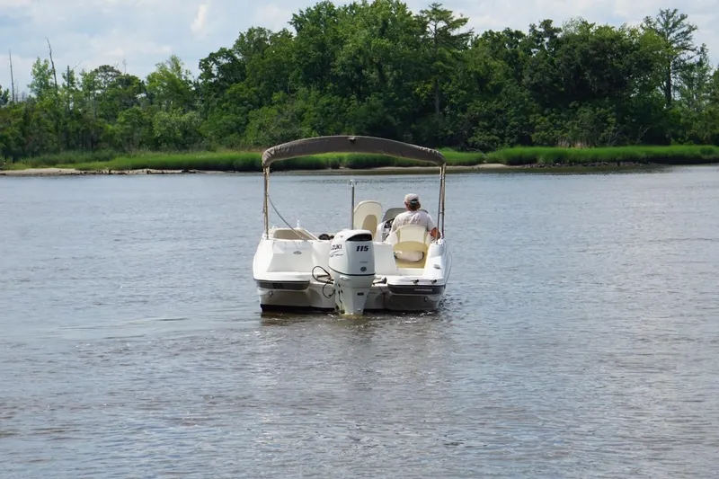 Slide: The Image of 2016 Stingray 192 SC boat cruising on a calm river with lush green shoreline. - 1