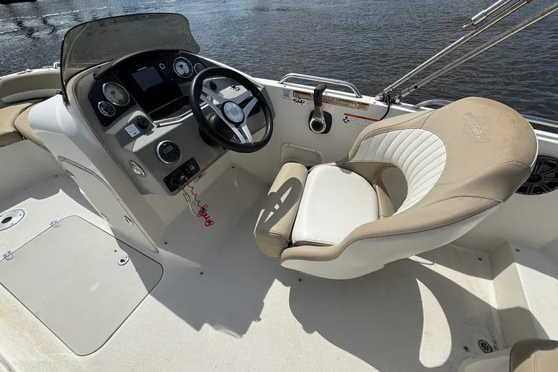 Slide: The Image of 2016 Stingray 192 SC boat interior with steering wheel and captain's seat by the water. - 11
