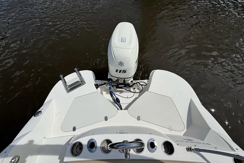 Slide: The Image of 2016 Stingray 192 SC boat with outboard motor on calm water. - 12