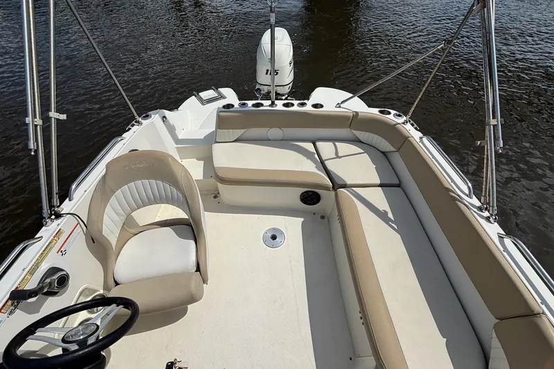 Slide: The Image of 2016 Stingray 192 SC boat interior with seating and steering wheel on water. - 13