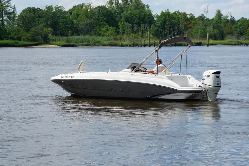 Slide: The Image of 2016 Stingray 192 SC boat cruising on a calm river with lush green shoreline. - 2