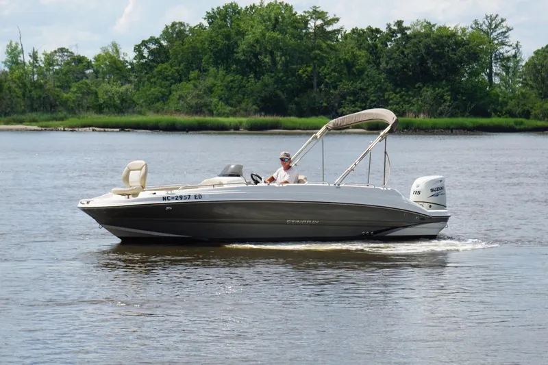 Slide: The Image of 2016 Stingray 192 SC boat cruising on a calm river with lush green trees in the background. - 3