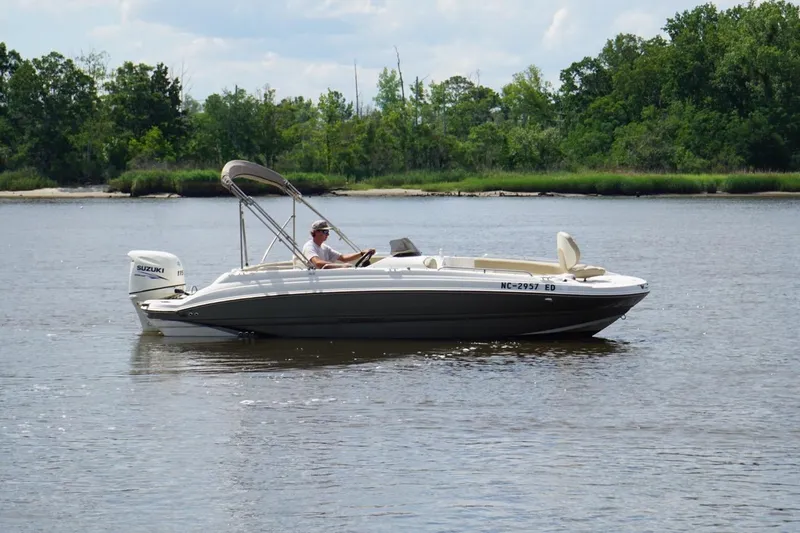 Slide: The Image of 2016 Stingray 192 SC boat cruising on a calm river with lush green shoreline. - 6