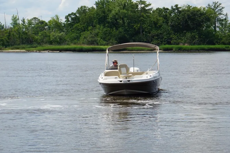 Slide: The Image of 2016 Stingray 192 SC boat cruising on a calm river with lush green trees. - 7