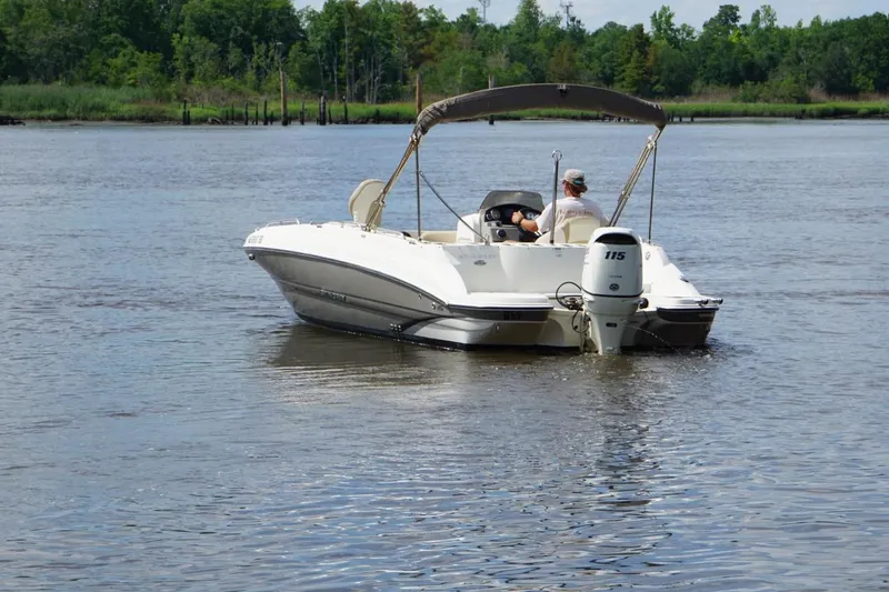 Slide: The Image of 2016 Stingray 192 SC boat cruising on a calm river with lush green shoreline. - 8