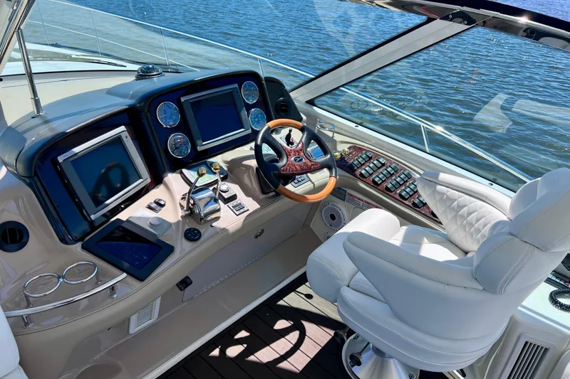 Slide: The Image of Cockpit of 2004 Sea Ray 500 Sundancer yacht with modern navigation equipment and luxurious seating. - 14