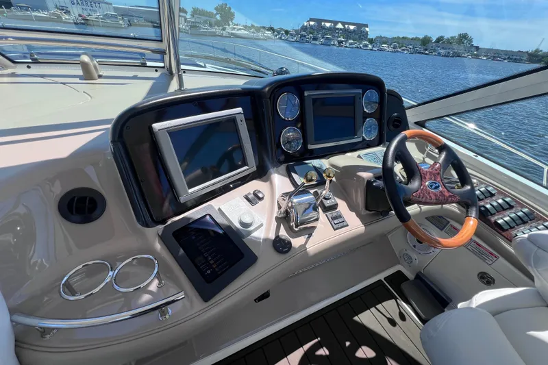 Slide: The Image of 2004 Sea Ray 500 Sundancer helm with advanced navigation controls and luxurious steering wheel. - 15
