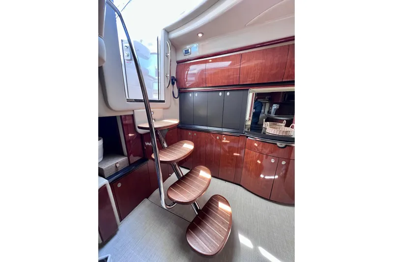 Slide: The Image of Interior of 2004 Sea Ray 500 Sundancer yacht with elegant wooden cabinetry and spiral staircase. - 27