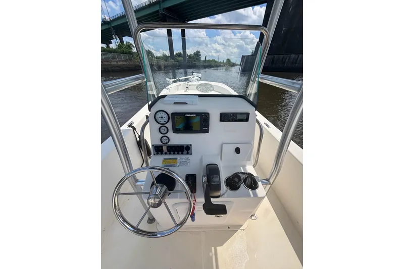 Slide: The Image of Center console of a 2016 Sundance DX22 boat with steering wheel and navigation instruments. - 14