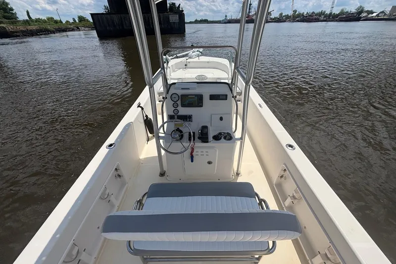 Slide: The Image of 2016 Sundance DX22 boat interior with steering console on a calm river. - 15