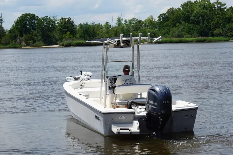 Slide: The Image of 2016 Sundance DX22 boat with Yamaha 115 engine on a calm river. - 2