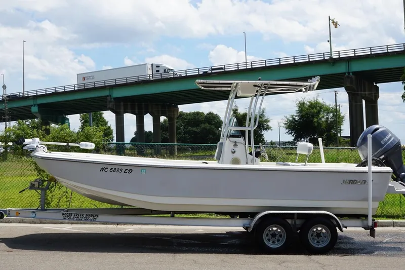 Slide: The Image of 2016 Sundance DX22 boat on trailer near highway bridge, sunny day. - 4