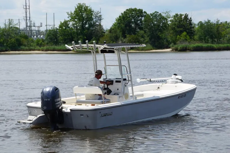 Slide: The Image of 2016 Sundance DX22 boat on a calm river, featuring a Yamaha outboard motor. - 5