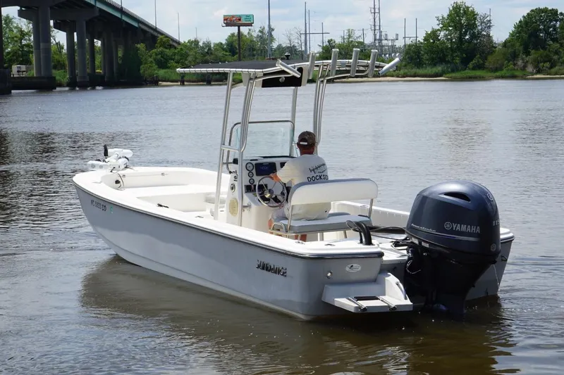 Slide: The Image of 2016 Sundance DX22 boat with Yamaha motor on a calm river near a bridge. - 7
