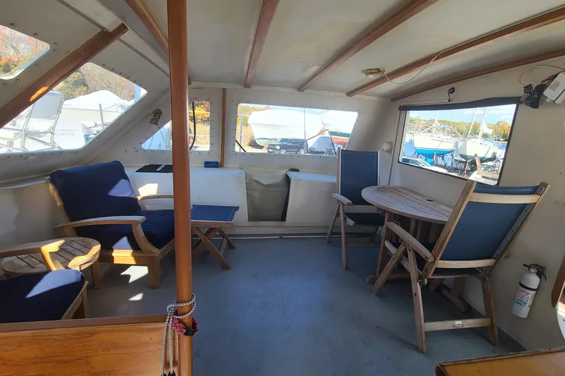 Slide: The Image of Interior of 2000 Crowther Catamaran with wooden furniture and blue cushions. - 17