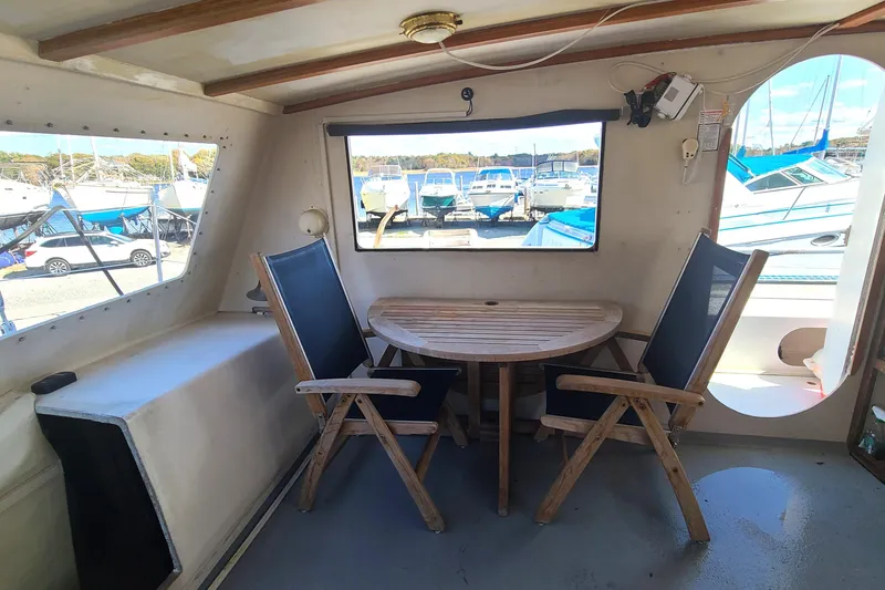 Slide: The Image of Interior of a 2000 Crowther Catamaran with wooden table and chairs, marina view. - 19
