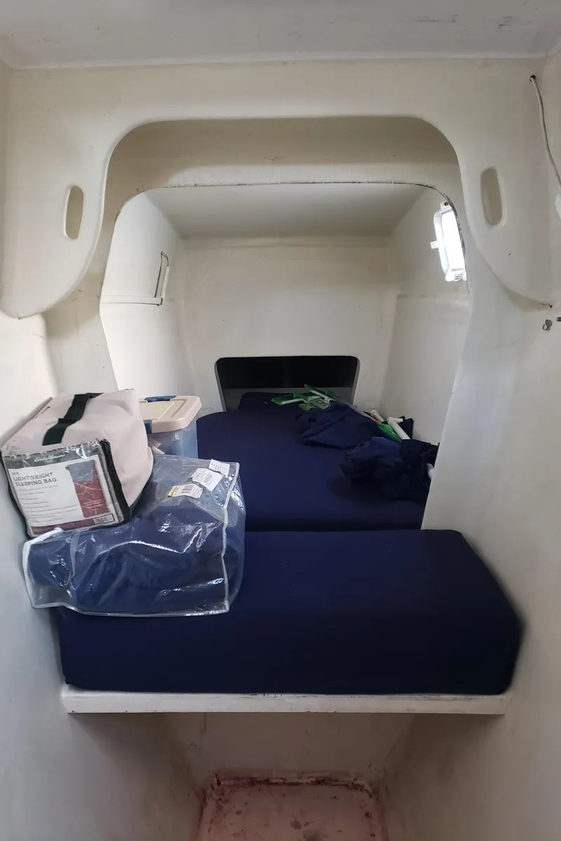Slide: The Image of Interior cabin of a 2000 Crowther Catamaran with blue bedding and storage items. - 20