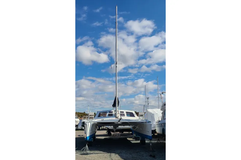 Slide: The Image of Crowther Catamaran 2000 on land, under a clear blue sky with scattered clouds. - 4