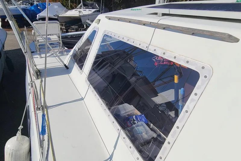 Slide: The Image of Crowther Catamaran 2000 with reflective windows, docked among other boats. - 7