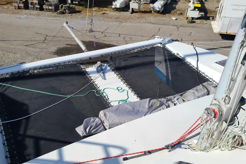 Slide: The Image of Crowther Catamaran 2000 with netting and ropes on deck, docked in a marina. - 9