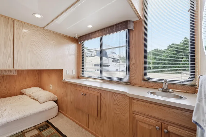 Slide: The Image of Interior of 2002 Sumerset 16x75 houseboat with wood paneling, bed, and window view. - 88