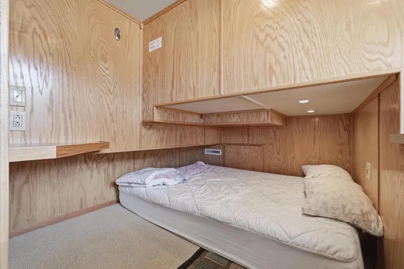 Slide: The Image of Cozy wooden cabin bedroom in a 2002 Sumerset 16x75 houseboat with a single bed. - 87