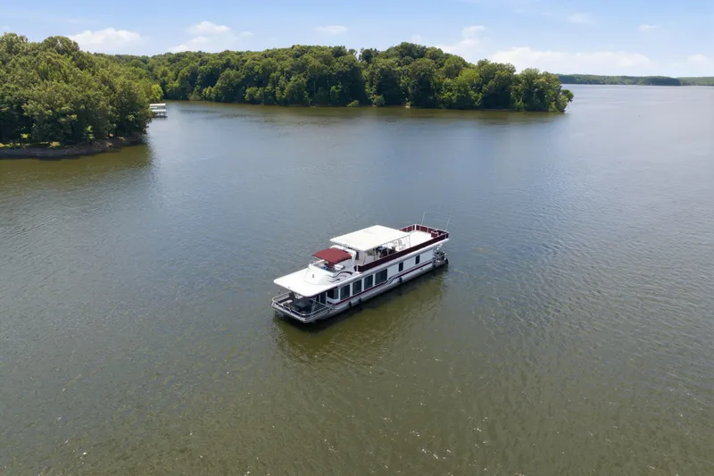 Slide: The Image of Houseboat on a serene lake, Sumerset 16x75, 2002 model, surrounded by lush greenery. - 15