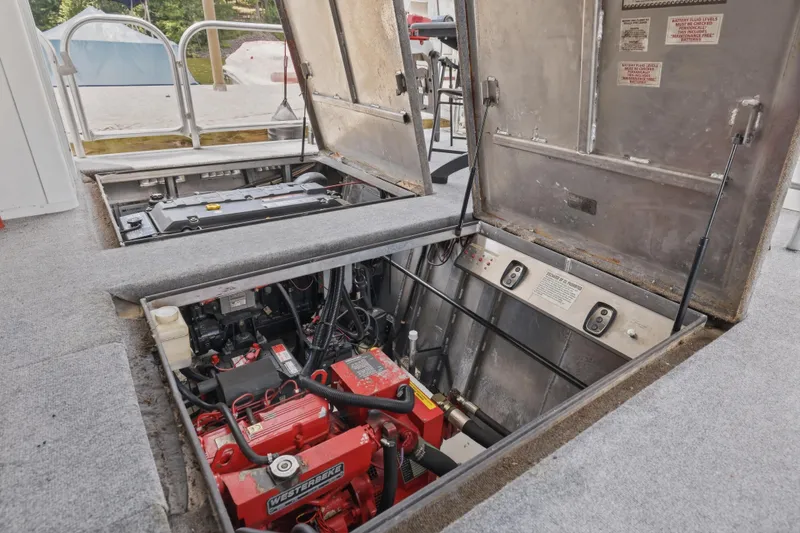 Slide: The Image of Engine compartment of a 2002 Sumerset 16x75 houseboat, showcasing mechanical components and wiring. - 46