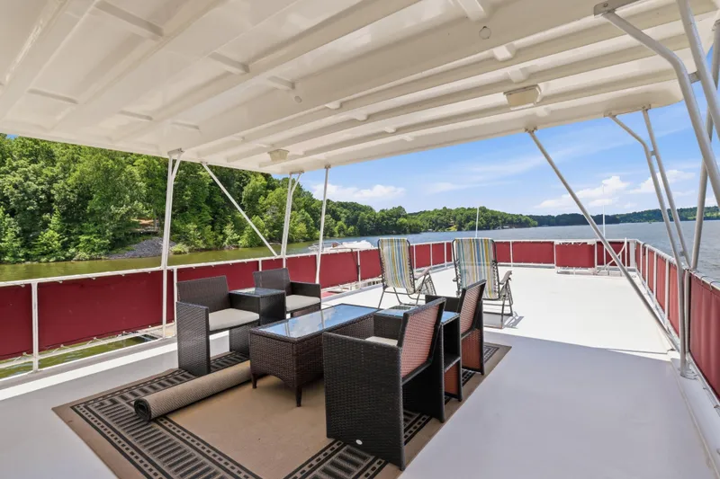 Slide: The Image of Spacious deck of 2002 Sumerset 16x75 houseboat with outdoor seating and scenic lake view. - 30