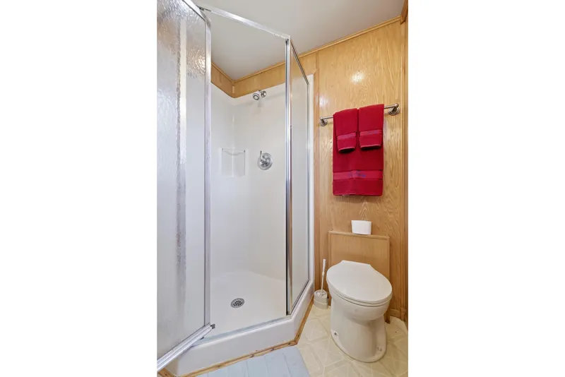 Slide: The Image of Bathroom in 2002 Sumerset 16x75 houseboat with shower, toilet, and red towels. - 80