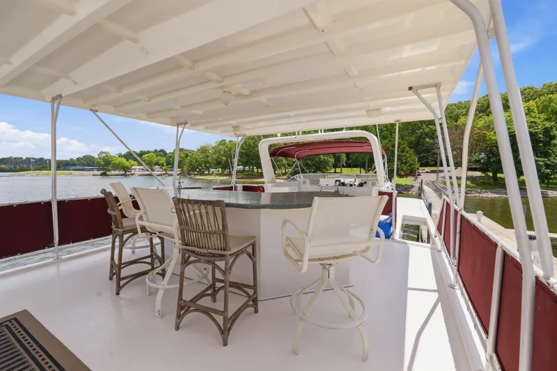Slide: The Image of Upper deck of a 2002 Sumerset 16x75 houseboat with bar seating and scenic lake view. - 31