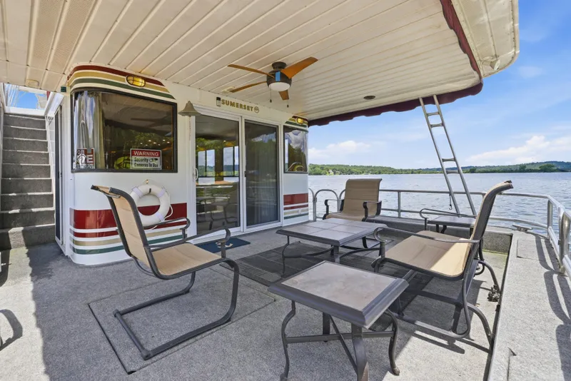 Slide: The Image of 2002 Sumerset 16x75 houseboat with outdoor seating on a serene lake. - 21