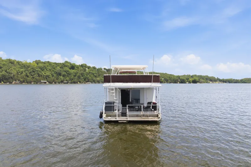 Slide: The Image of 2002 Sumerset 16x75 houseboat on a serene lake with lush green shoreline. - 8